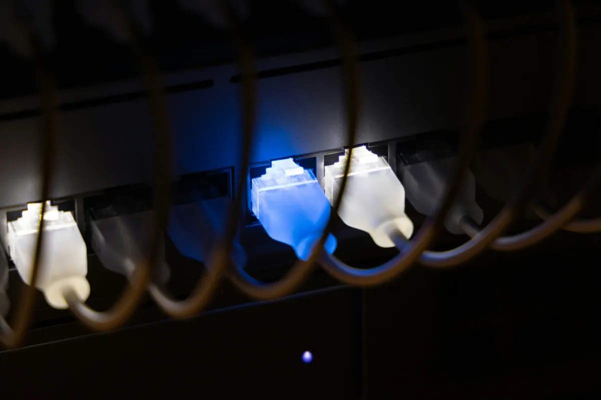 Close-up of network switch with illuminated ethernet cables